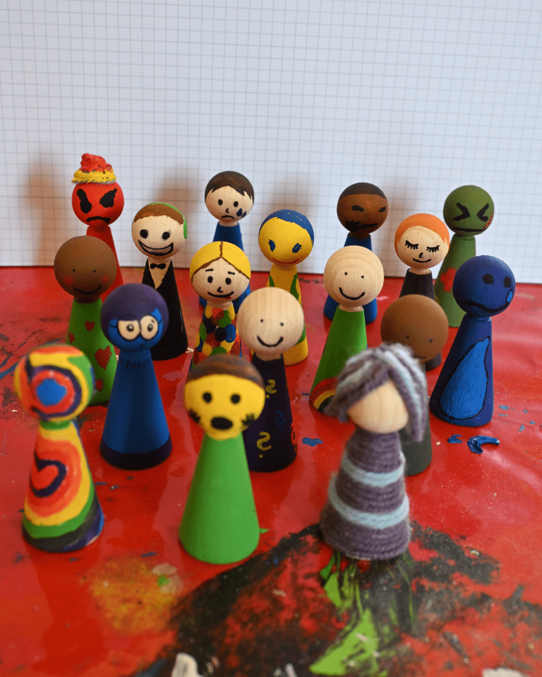 Holzfiguren die auf dem Wochenede bemalt wurden und verschiedene Emotionen darstellen.